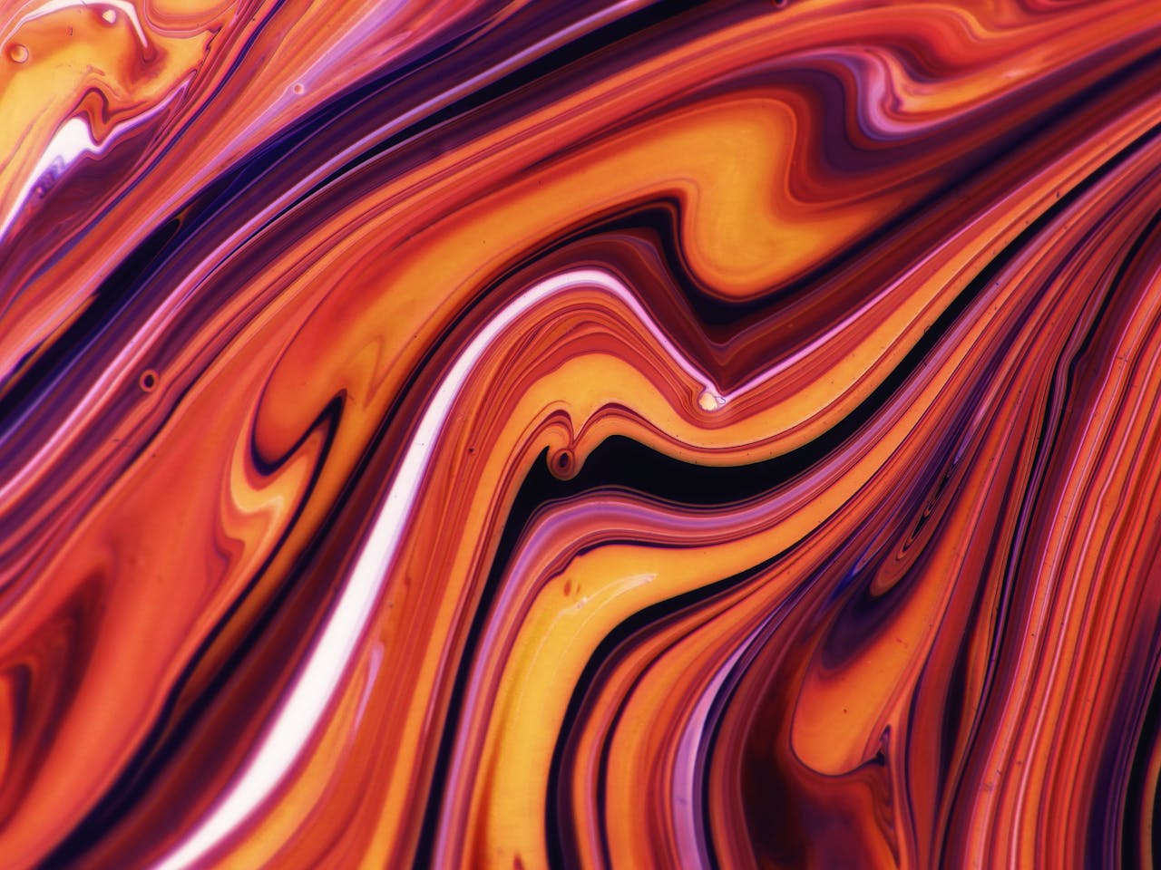 Dynamic abstract artwork featuring swirling vibrant colors and fluid patterns.